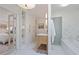 Bright bathroom with marble tile floor, wooden vanity, and adjacent soaking tub and ensuite bedroom at 80 Seville Chase, Atlanta, GA 30328