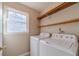 Functional laundry room with washer, dryer, and convenient shelving above at 3005 Summit View Ct, Snellville, GA 30078