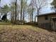 View of the side yard and back, showing exterior, storage sheds, and natural landscaping at 302 Chattahoochee Way, Woodstock, GA 30188