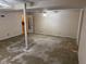 Unfinished basement features a ceiling fan, support beams, and an adjacent storage area via open door at 302 Chattahoochee Way, Woodstock, GA 30188