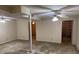 Large unfinished basement area with support beams, a ceiling fan, and access to adjacent room with shelving at 302 Chattahoochee Way, Woodstock, GA 30188