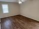 Bedroom showcasing hardwood floors, a ceiling fan, and natural light from a window at 302 Chattahoochee Way, Woodstock, GA 30188