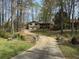 Exterior view of home with long driveway and meticulous landscaping, including small bridge and rockwork features at 302 Chattahoochee Way, Woodstock, GA 30188