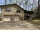 Home with two-car garage and stone accents, featuring a covered porch and wood siding at 302 Chattahoochee Way, Woodstock, GA 30188