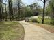 Exterior view of home with long driveway, small bridge, and rockwork leading up to the residence at 302 Chattahoochee Way, Woodstock, GA 30188
