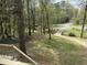 View of the front yard showing mature trees and driveway leading to the home at 302 Chattahoochee Way, Woodstock, GA 30188