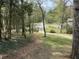 View of the front yard showing mature trees and driveway leading to the home at 302 Chattahoochee Way, Woodstock, GA 30188