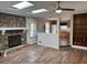 Open-concept living room with stone fireplace, skylights, wood floors, and view into kitchen at 302 Chattahoochee Way, Woodstock, GA 30188