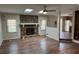 Living room with a stone fireplace, skylights, and wood floors, seamlessly connecting to the kitchen at 302 Chattahoochee Way, Woodstock, GA 30188