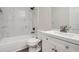 Bright bathroom boasting a modern vanity, white cabinets, and a bathtub with tiled walls at 714 Post Road Dr, Stone Mountain, GA 30088