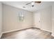 Bright bedroom with hardwood floors, a ceiling fan, and a window showcasing the greenery outside at 714 Post Road Dr, Stone Mountain, GA 30088