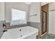 Bright bathroom featuring a soaking tub under a window and a separate tiled shower at 95 Summerlyn Dr, Hiram, GA 30141