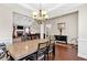 Open concept dining area with a chandelier, wood floors, and adjacent living room at 95 Summerlyn Dr, Hiram, GA 30141