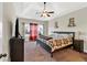 Comfortable main bedroom suite featuring a tray ceiling, a ceiling fan, and ample natural light at 95 Summerlyn Dr, Hiram, GA 30141