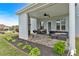 Inviting covered patio with stone fireplace, comfortable outdoor seating, and landscaped garden beds at 95 Summerlyn Dr, Hiram, GA 30141