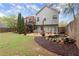 Backyard featuring a deck, dining area, rock-lined pond, fire pit, and green lawn at 104 Puckett Creek Dr, Canton, GA 30114