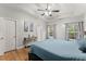 Comfortable main bedroom featuring a tray ceiling, ceiling fan, and two windows with a wooded backyard view at 104 Puckett Creek Dr, Canton, GA 30114