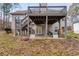Backyard featuring a wooden deck with stairs, a covered patio, green lawn, and minimal landscaping at 1409 Northgate Dr, Villa Rica, GA 30180