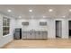 Well-lit basement featuring a stylish wet bar with gray cabinets, marble countertop, and stainless steel mini-fridge at 1409 Northgate Dr, Villa Rica, GA 30180