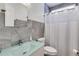 Modern bathroom with gray tiling, glass countertop sink, a toilet, and shower with curtain at 1409 Northgate Dr, Villa Rica, GA 30180