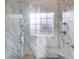 Close up of the glass enclosed shower with a marble seat at 1409 Northgate Dr, Villa Rica, GA 30180