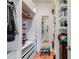 Organized walk-in closet with shelving, hanging rods, drawers, full length mirror, and decorative stool at 1409 Northgate Dr, Villa Rica, GA 30180