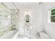 Bright bathroom with marble backsplash, decorative sink, tub and chrome fixtures at 235 The Prado N, Atlanta, GA 30309