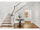 Elegant foyer with hardwood floors, staircase, wainscoting, and arched doorway at 235 The Prado N, Atlanta, GA 30309
