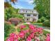 Charming two-story home with lush landscaping, including vibrant roses and mature trees at 235 The Prado N, Atlanta, GA 30309
