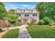 Beautiful two-story house with dormer windows, shutters, manicured lawn, lush landscaping and stone path at 235 The Prado N, Atlanta, GA 30309
