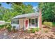 Charming home featuring a brick chimney, red door, black shutters, and well-maintained landscaping at 235 The Prado N, Atlanta, GA 30309