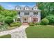 Inviting two-story home with a covered porch, shuttered windows, well-manicured lawn, and stone pathway at 235 The Prado N, Atlanta, GA 30309