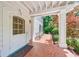Inviting front porch with a red tile floor, ample seating and a decorative screen door at 235 The Prado N, Atlanta, GA 30309