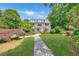 Stunning two-story home with lush green lawn, beautiful landscaping, and a stone pathway, surrounded by mature trees at 235 The Prado N, Atlanta, GA 30309