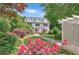 Charming two-story home with lush landscaping, a stone pathway, and vibrant flowers, framed by mature trees at 235 The Prado N, Atlanta, GA 30309