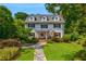 Charming two-story home featuring dormer windows, a manicured lawn and a stone walkway leading to the front door at 235 The Prado N, Atlanta, GA 30309