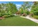 Spacious front yard with lush green grass, lovely landscaping, a stone pathway, and mature trees at 235 The Prado N, Atlanta, GA 30309