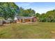 Sprawling backyard featuring a covered patio area, lush lawn, mature trees, and partial fencing at 3113 Octavia Pl, Atlanta, GA 30340