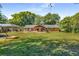 Large, well-maintained backyard with lush green grass, a covered patio, mature trees, and play structure at 3113 Octavia Pl, Atlanta, GA 30340
