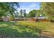 Expansive backyard with mature trees, a shed, play structure, and a covered patio, perfect for entertaining at 3113 Octavia Pl, Atlanta, GA 30340