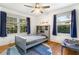 Neutral toned bedroom featuring a ceiling fan, hardwood floors, and large windows with outdoor views at 3113 Octavia Pl, Atlanta, GA 30340