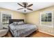 Comfortable bedroom featuring a ceiling fan, hardwood floors, and natural light from two windows at 3113 Octavia Pl, Atlanta, GA 30340