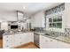Open concept kitchen with white cabinetry, granite countertops, stainless steel appliances, and designer backsplash at 3113 Octavia Pl, Atlanta, GA 30340