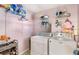 Functional laundry room with washer, dryer, storage shelves and pink paint at 3113 Octavia Pl, Atlanta, GA 30340