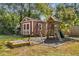 Backyard featuring a playhouse, swing set, and sandbox surrounded by trees and mulch at 3113 Octavia Pl, Atlanta, GA 30340