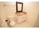Bathroom with toilet and vanity featuring granite counters and framed mirror at 1075 Peachtree Ne Walk # A519, Atlanta, GA 30309