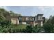 Contemporary home with mixed material facade, clean lines, and landscaped front yard, nestled among mature trees at 2413 Spalding Dr, Atlanta, GA 30350