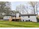 Back of house with wooden deck, chimney, and many windows and doors, and lush trees at 2923 Glenhaven Sw Ct, Conyers, GA 30094