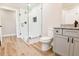 Well-lit bathroom featuring a glass shower, gray vanity with granite counters, and wood-look vinyl flooring at 2923 Glenhaven Sw Ct, Conyers, GA 30094