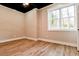 Bedroom featuring new vinyl floors, neutral paint, white trim, and a window for natural light at 2923 Glenhaven Sw Ct, Conyers, GA 30094